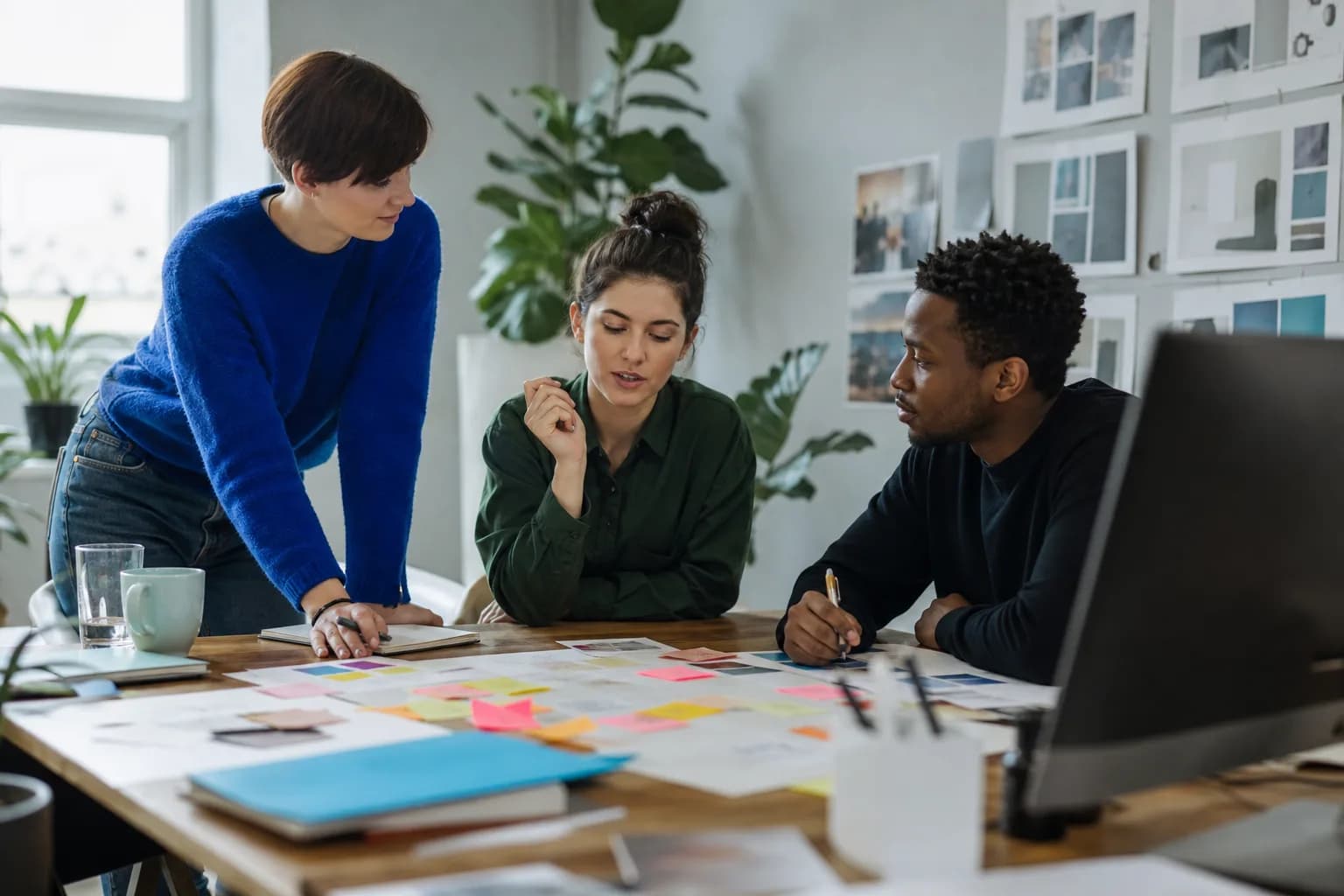 Small marketing agency team planning a campaign around a studio table