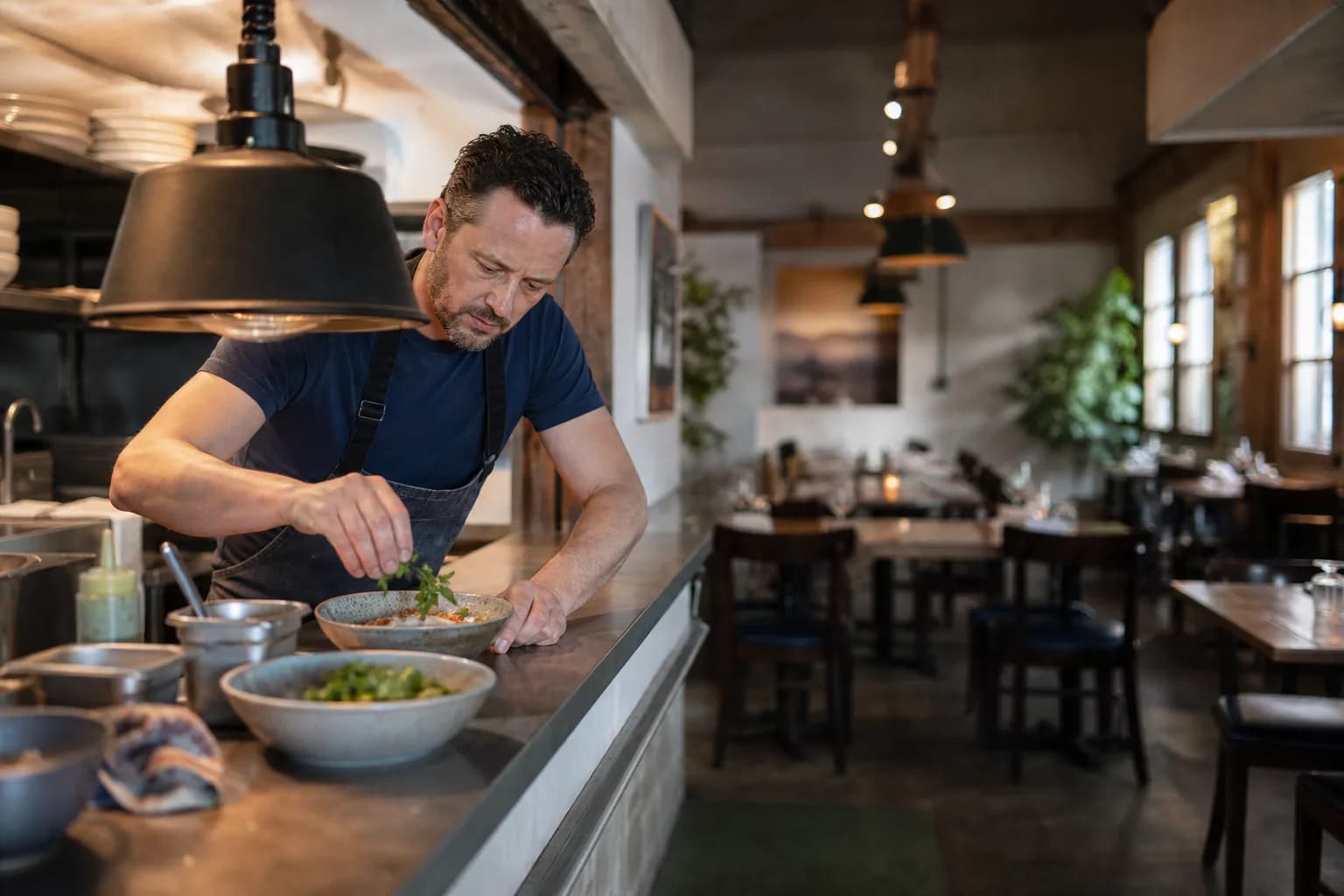 Independent restaurant chef-owner finishing a dish before neighborhood dinner service